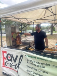 a man is preparing food at a food stand