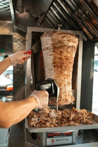 a woman is preparing a gyro in a food truck